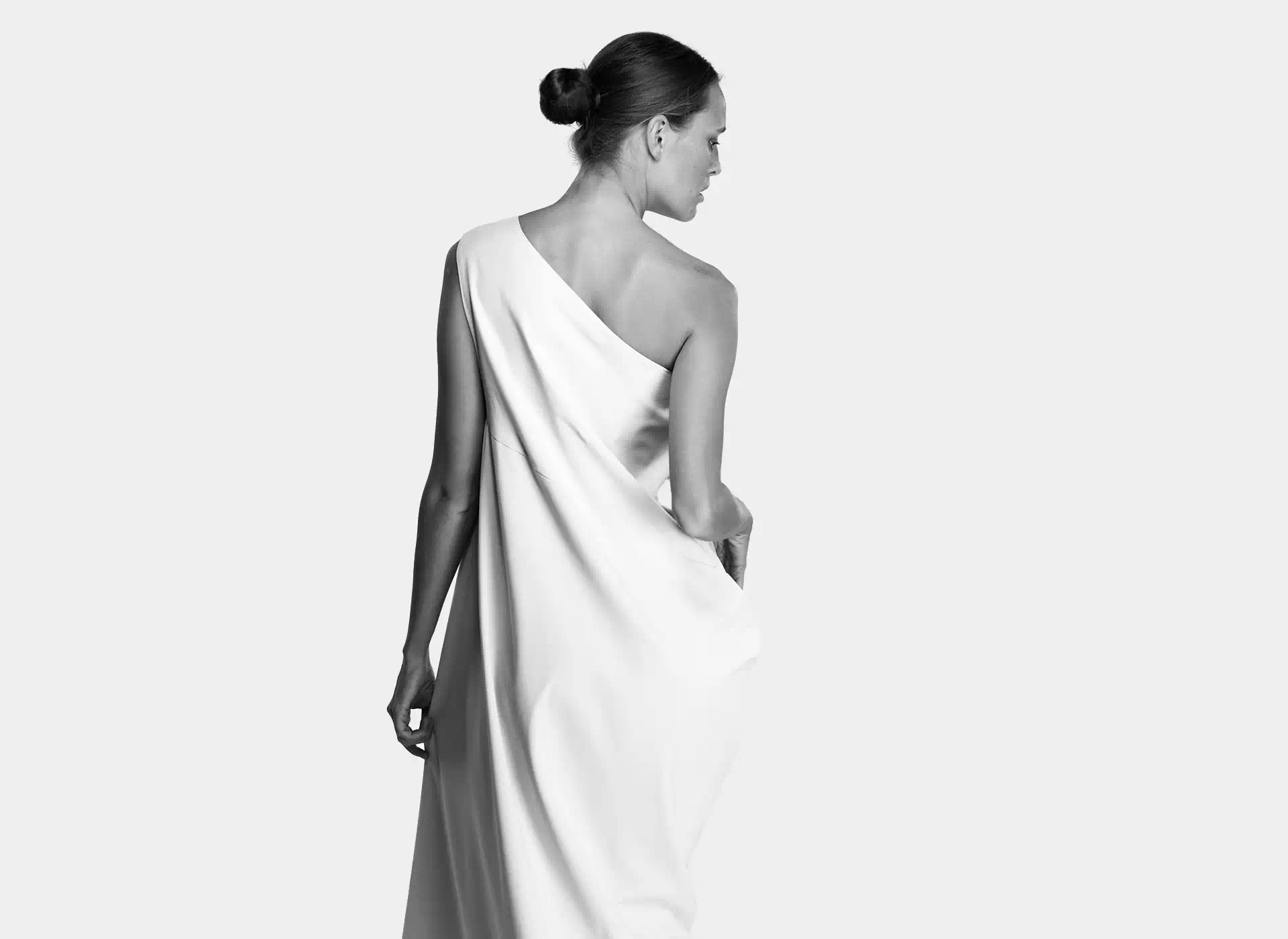 Kobieta stojąca tyłem w białej sukni